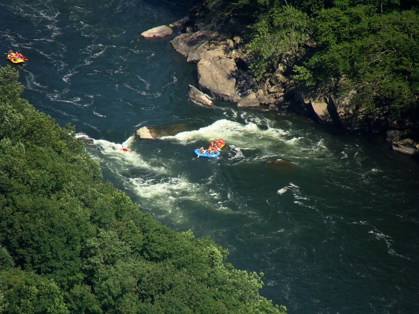 Whitewater rafts running a rapid on the New River, seen from high above at Diamond Point